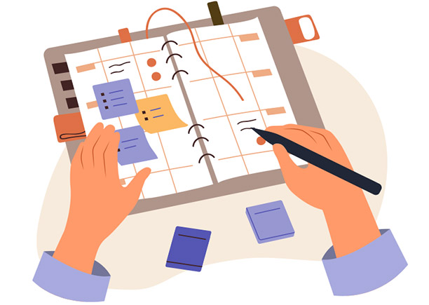 Hands using a pen to write on a planner